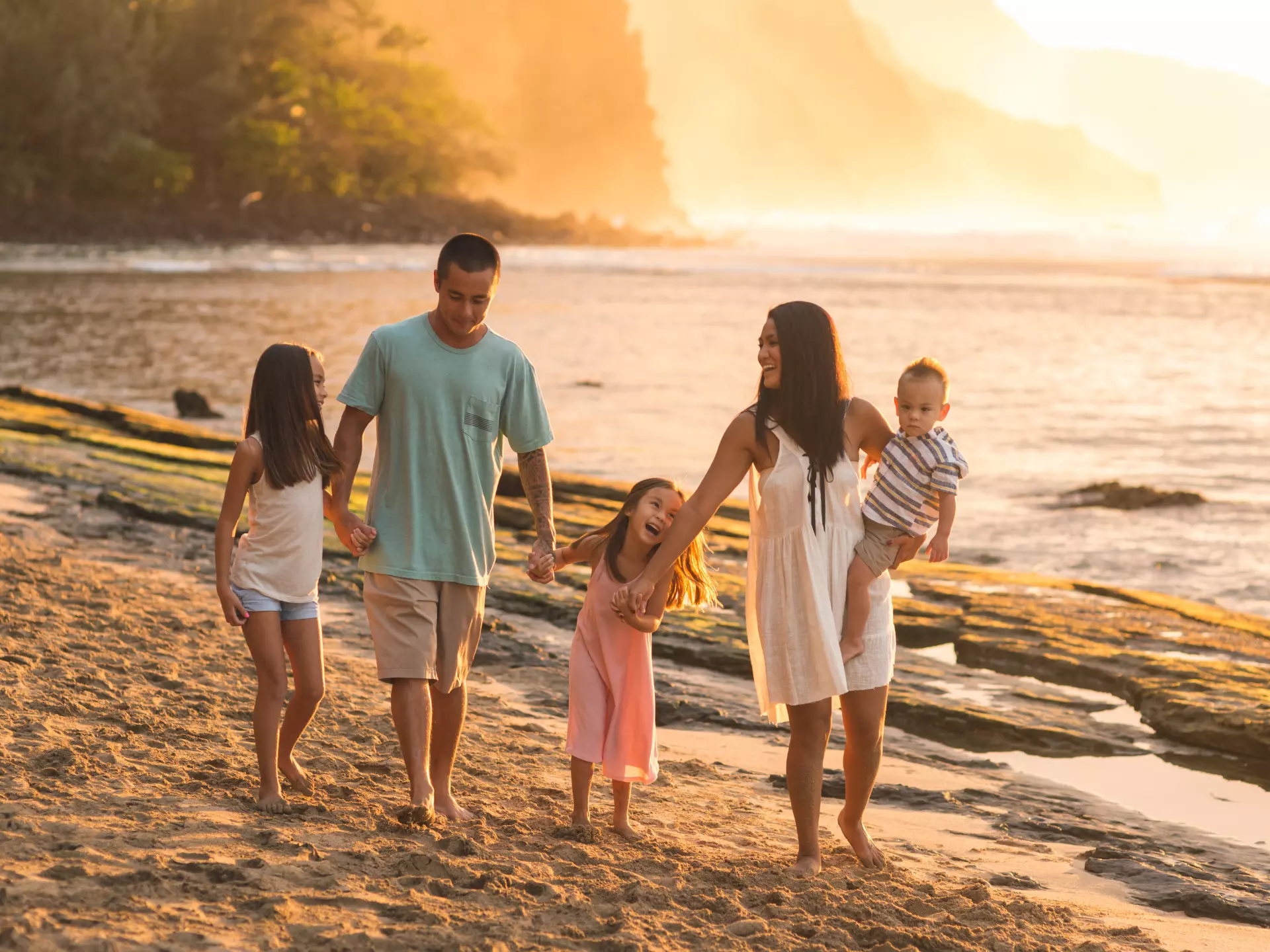 A family of five on vacation and enjoying the sunset by the beach