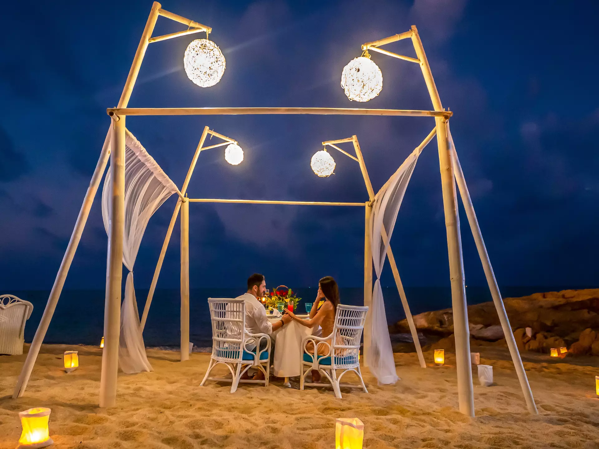 A couple having a romantic dinner at the beach of Garrya Tongsai Bay Samui