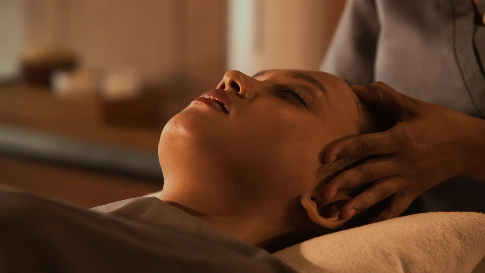 A woman is enjoying head massage in spa room