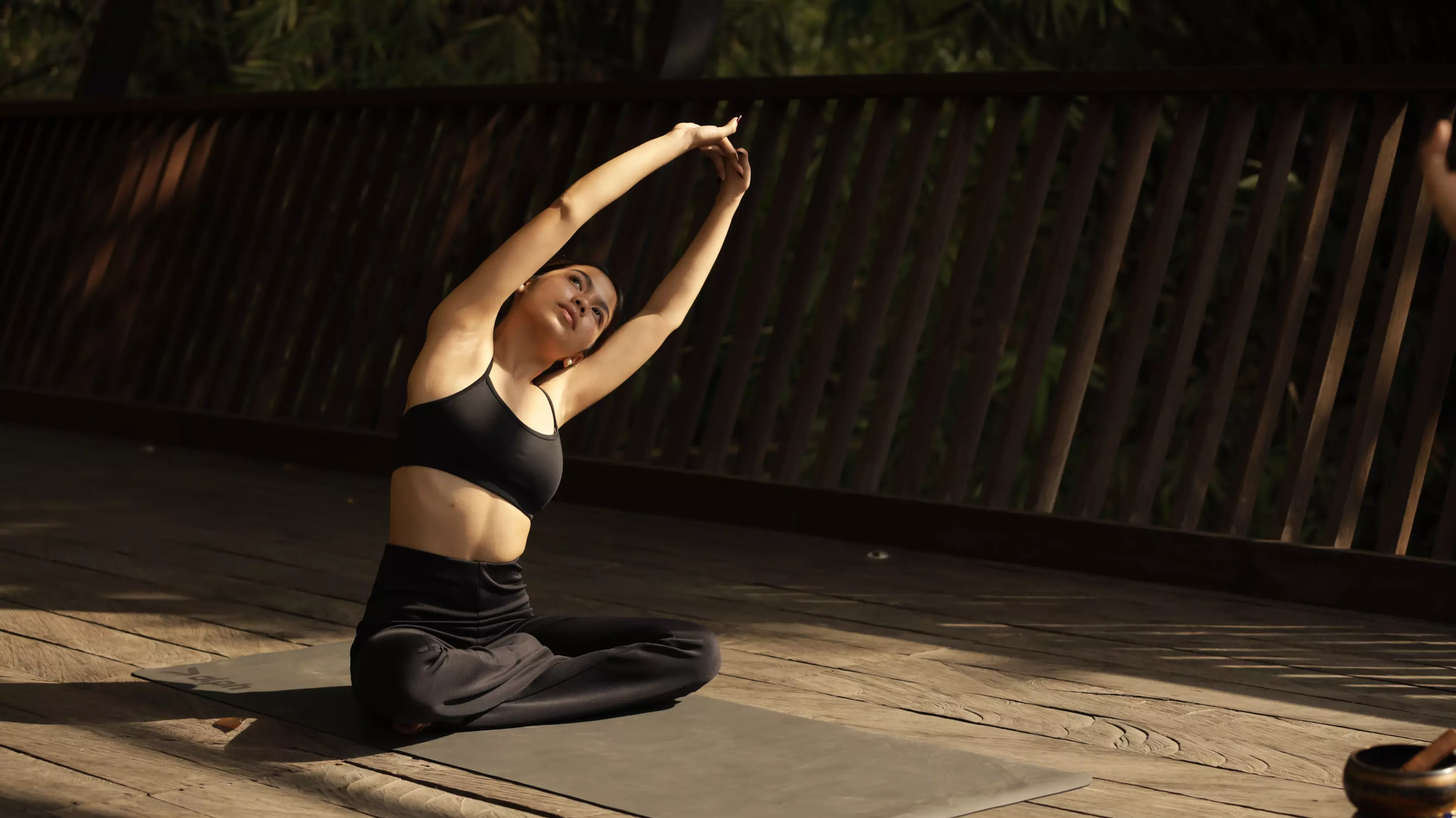A woman is having yoga session at the riverside deck