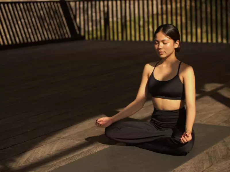 a women is meditating at the riverside deck
