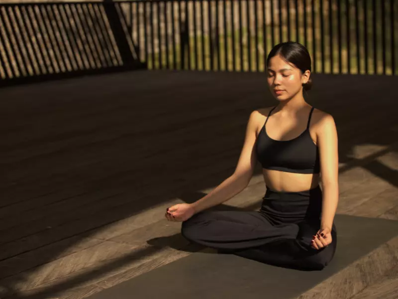 a woman is doing a meditation on a deck