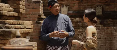 Javanese cultural experience at Garrya Bianti Yogyakarta with a guest learning from a local guide surrounded by traditional brick architecture at Kotagede