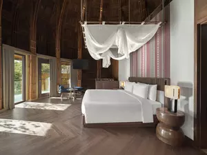 Mù Cang Chải Pool Suite bedroom overlooking rice terraces and forested mountains with natural sunlight.