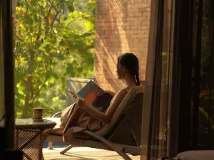 a woman is reading a book in room