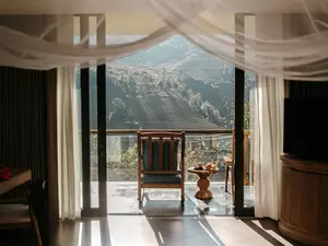 Suite balcony with mountain and terraced field views framed by soft morning light at Garrya Mu Cang Chai.