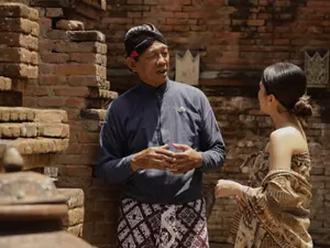 Javanese cultural experience at Garrya Bianti Yogyakarta with a guest learning from a local guide surrounded by traditional brick architecture at Kotagede
